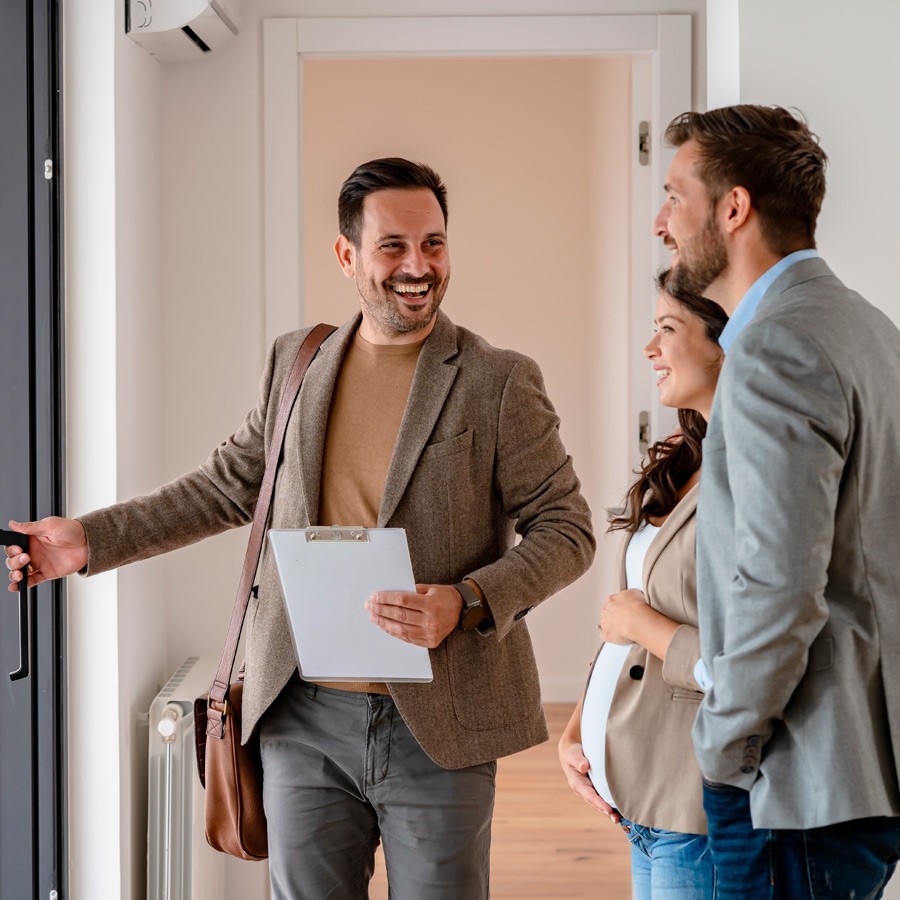 Real Estate Agent showin a house to a couple Image of a Real Estate Agent showin a house to a couple